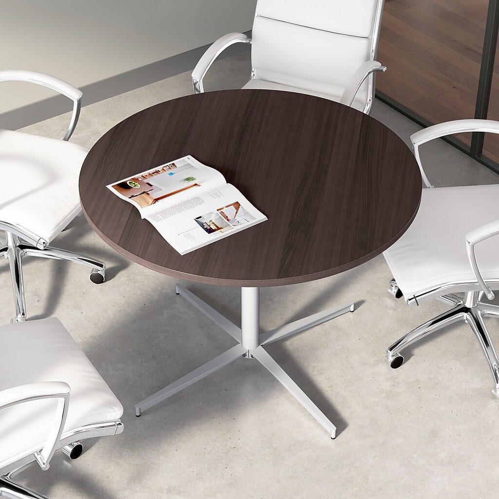 Top view of round dark wood conference table with white chairs around