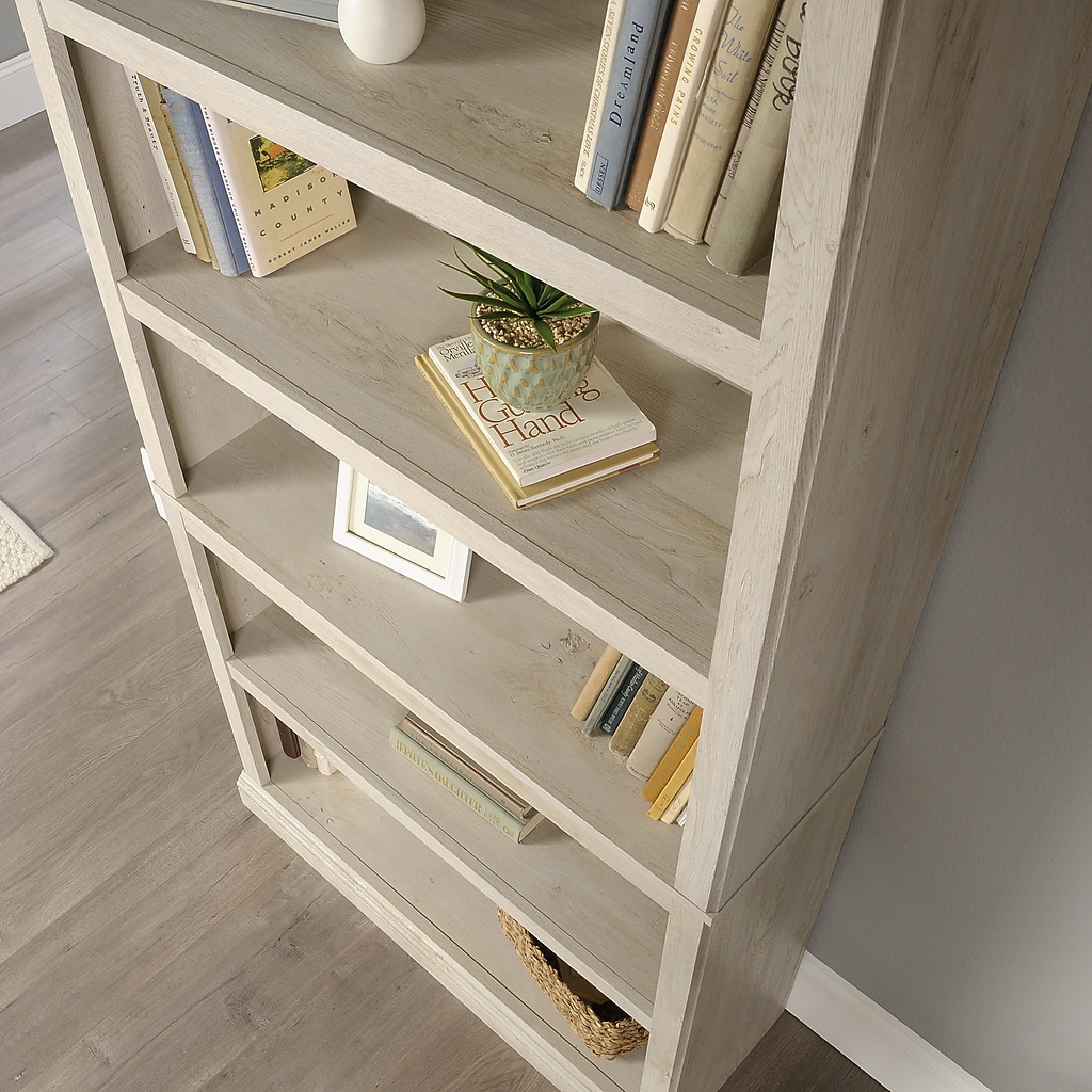 Close-up of top shelves and side of bookcase with books and decor