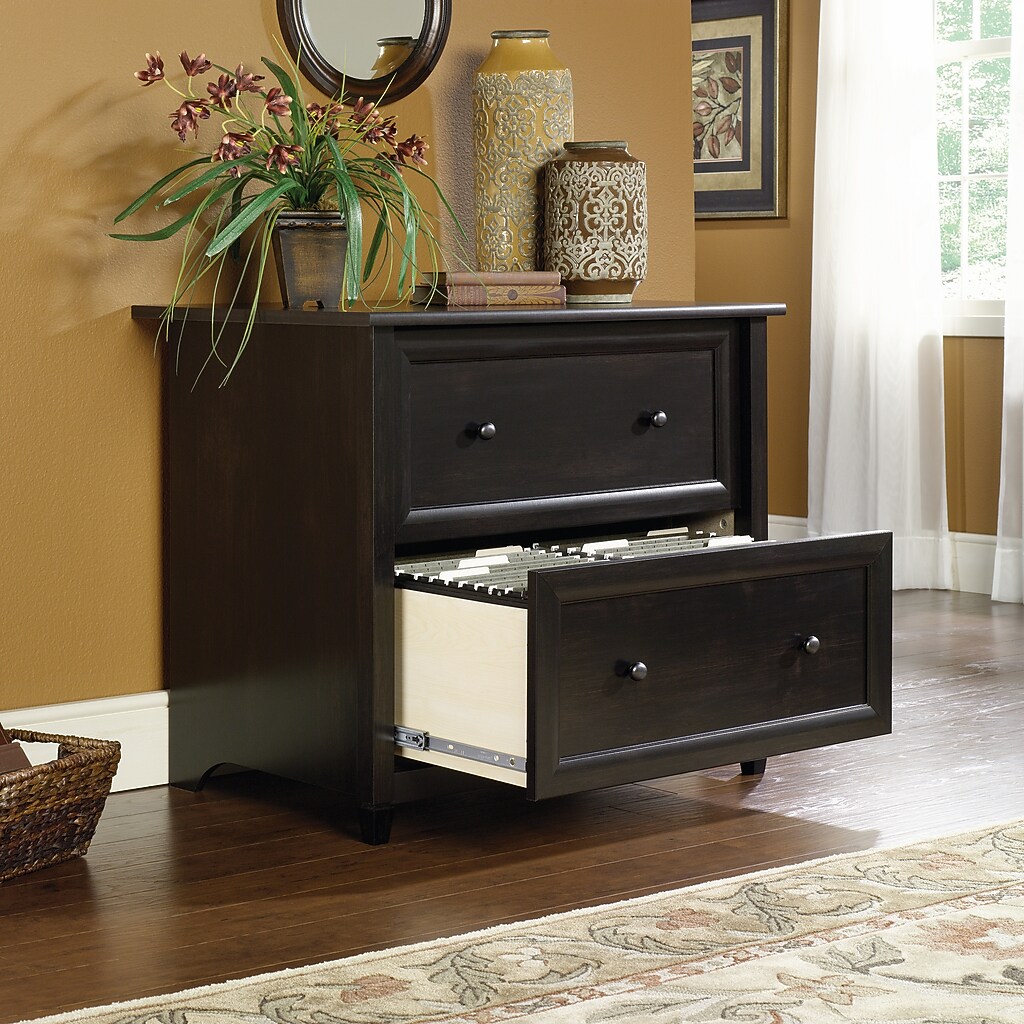 Open drawer of dark wood file cabinet showing interior