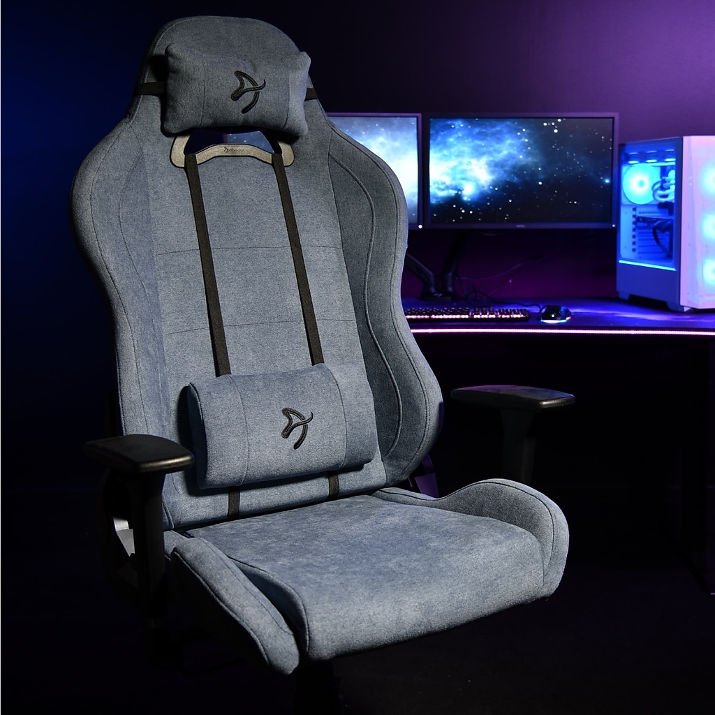 Blue Arozzi Torretta gaming chair in a dark room with computer setup