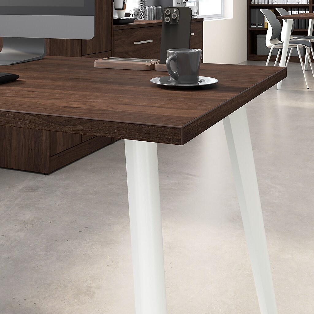 Close-up of dark wood desk surface and white angled leg