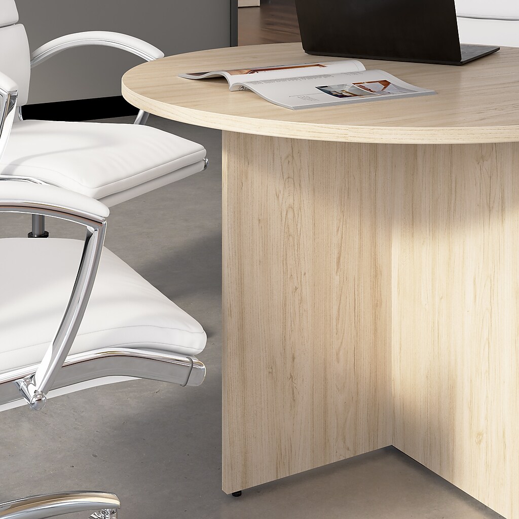 Round conference table with laptop and magazine, showing side view