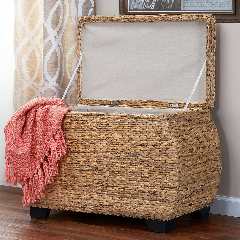 Woven storage chest used as furniture with a blanket draped