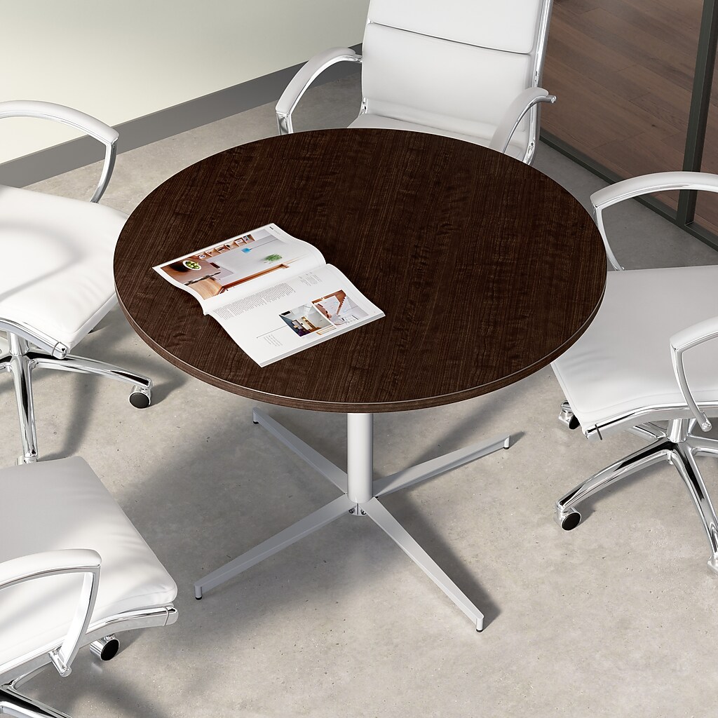 Top view of round dark wood table with white chairs around