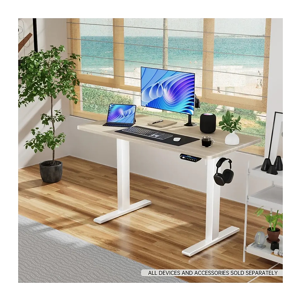 Desk in a home office with monitor, plants and headphones
